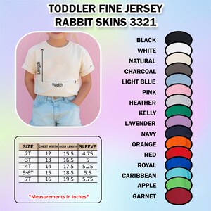 May include: A cream-colored toddler fine jersey t-shirt with rolled-up sleeves. The image includes a size chart with chest width, body length, and sleeve measurements in inches. Color options are displayed, including black, white, and pink.