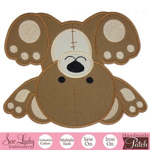 May include: Brown and beige embroidered iron-on patch of a teddy bear with its arms outstretched. The patch says "Handmade Patch" at the bottom.