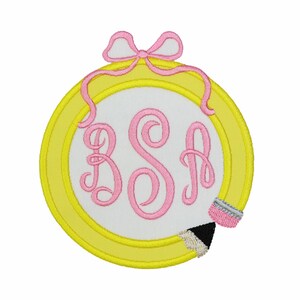 May include: A circular embroidered patch featuring a yellow hoop frame with a pink bow at the top. The center is white with the pink monogram letters BSA in a cursive script. A small pencil with a pink eraser is attached to the bottom right.