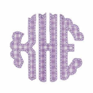 May include: A monogram applique featuring the letters K, H, and E in a decorative font style. The letters are crafted from a light purple and white gingham checkered fabric, finished with a matching purple stitched border around the edges.