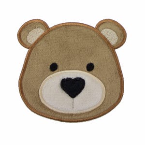 May include: A tan bear head patch with a fuzzy texture, featuring rounded ears with cream-colored centers, two small black circular eyes, and a white muzzle area with a prominent black heart-shaped nose, all outlined in a dark brown thread border.