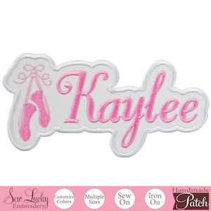 May include: Pink and white embroidered iron-on patch with the name "Kaylee" and a pair of pink ballet shoes. The patch is handmade and can be sewn or ironed on.
