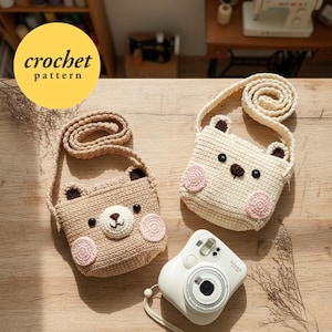 May include: Two crochet bear-shaped crossbody bags in beige and cream colors, with pink cheeks and black button eyes. The bags have long straps and are displayed with a white camera. The image includes a yellow circle with the text "crochet pattern".