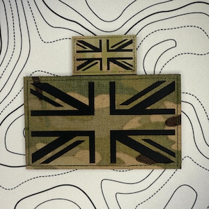Peut inclure: Deux écussons en tissu camouflage représentant le drapeau Union Jack. Le plus grand est rectangulaire, le plus petit est carré. Le motif noir du drapeau ressort sur le fond camouflage.