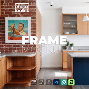 May include: A square white picture frame mockup hanging on a red brick wall in a kitchen. The frame displays a vintage-style illustration of a person in a red convertible car giving a thumbs up. The kitchen features light wood cabinets and counters.