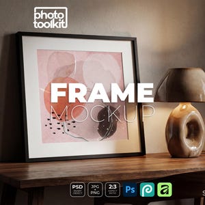 Peut inclure: Maquette d'impression d'art encadrée avec le texte "FRAME MOCKUP". L'œuvre d'art présente des formes abstraites en rose, orange et noir. Une lampe marron est posée sur une table en bois à côté du cadre. L'image est une maquette de produit.