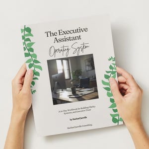 Könnte beinhalten: Ein Arbeitsbuch mit dem Titel "The Executive Assistant Operating System" wird von zwei Händen gehalten. Das Cover ist hellbeige mit grünen Blättern und einem Foto eines Büros. Der Text enthält "A 30-Day Workbook for Building Clarity, Systems, and Executive Trust."