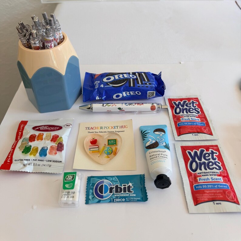 Peut inclure: Un porte-stylo en forme de crayon contenant des stylos, un paquet de biscuits Oreo, un stylo marqu&eacute; Best Teacher, deux paquets de lingettes antibact&eacute;riennes Wet Ones, un sachet d'oursons en g&eacute;latine Albanese, une carte en c&oelig;ur, de la cr&egrave;me pour les mains.