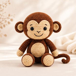 May include: A crocheted monkey doll in shades of brown and beige. The handmade stuffed animal has a round head, large ears, and a smiling face. The monkey is sitting with its arms and legs extended, and a curled tail.