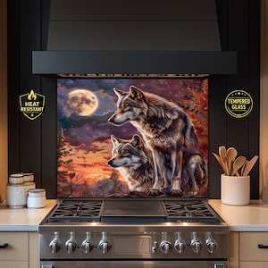 Puede incluir: Un protector contra salpicaduras de vidrio templado resistente al calor con una pintura detallada de dos lobos bajo la luna llena. La obra de arte muestra una vibrante puesta de sol con follaje otoñal, creando una escena dramática y naturalista.