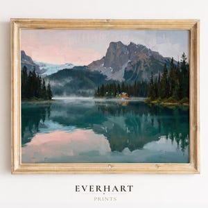 May include: A framed landscape painting depicts a serene lake scene with mountains in the background. The artwork features a golden frame and the text "EVERHART PRINTS" at the bottom. The painting showcases a reflection of the mountains and sky in the water.