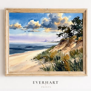 Pode incluir: Uma pintura em aquarela emoldurada retratando uma praia de areia com gramíneas de duna em primeiro plano, um oceano azul escuro e um horizonte urbano distante sob um céu cheio de nuvens iluminadas pelo sol. O texto EVERHART PRINTS aparece abaixo.