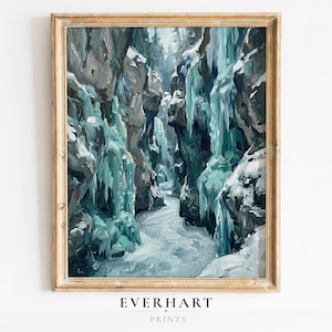Op de afbeelding: Een ingelijst landschapsschilderij dat een wintercanyontafereel uitbeeldt. Het kunstwerk toont een smalle kloof met ijzige formaties en sneeuw. Het kleurenpalet omvat tinten blauw, grijs en wit, met de tekst "EVERHART PRINTS" onderaan.