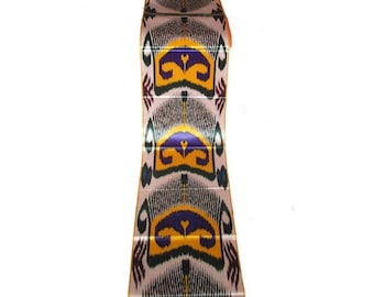 May include: A folded textile with a repeating pattern of stylized floral or geometric shapes in yellow, purple, green, and black on a cream background. The fabric appears to be silk or a similar material.