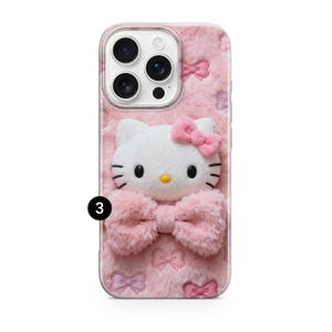 Może przedstawiać: R&oacute;żowe etui na telefon z białą postacią Hello Kitty z r&oacute;żową kokardą i puszystą r&oacute;żową kokardą na dole. Etui ma miękkie, teksturowane tło z małymi wzorami kokardek.