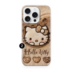 Może przedstawiać: Etui na telefon z motywem Hello Kitty. Etui ma puszyste, brązowe tło z twarzą i kokardą Hello Kitty. Słowa "Hello Kitty" są napisane pod postacią, wraz z trzema kształtami serca.