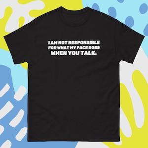 Könnte beinhalten: Schwarzes T-Shirt mit dem weißen Text: "I AM NOT RESPONSIBLE FOR WHAT MY FACE DOES WHEN YOU TALK." Das Shirt hat kurze Ärmel und einen Rundhalsausschnitt. Der Hintergrund hat ein farbenfrohes abstraktes Design.