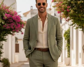 May include: A man wearing a light green suit with a beige shirt and brown belt. The suit has a two-button closure and a notched lapel. The man is also wearing sunglasses and is standing outside on a sunny day.