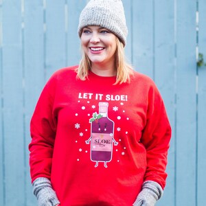 May include: Red Christmas sweater with a cartoon illustration of a bottle of sloe gin with the text "Let it Sloe!"