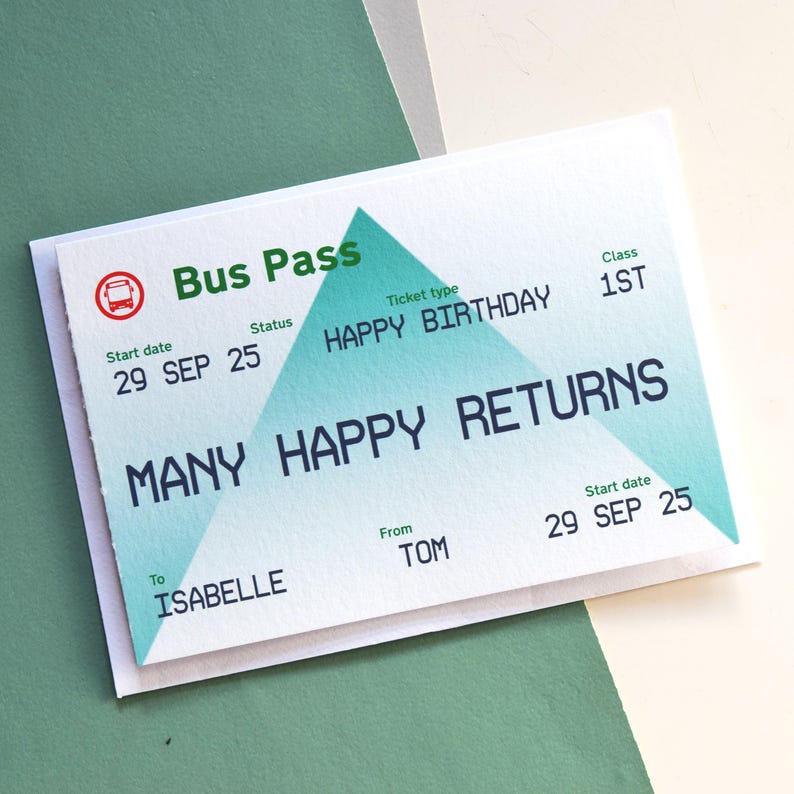May include: A white greeting card designed as a bus pass, with the words "Bus Pass" and "Happy Birthday" in green and blue. The card includes the text "Many Happy Returns" and the names "Isabelle" and "Tom".