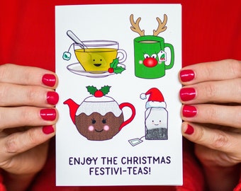 May include: A white card with a festive Christmas tea theme. The card features four illustrations of teacups, tea bags, and a Christmas pudding, all with cute faces. The text on the card reads "Enjoy the Christmas Festivi-Teas!"