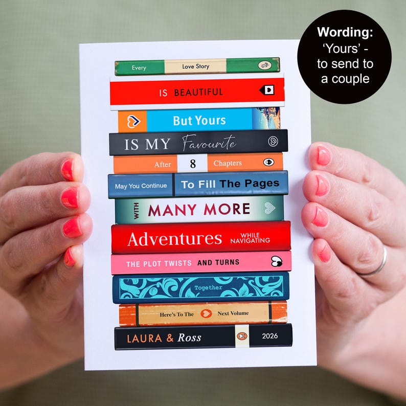 Puede incluir: Una tarjeta de felicitaci&oacute;n rectangular con una pila de lomos de libros coloridos con el texto Every Love Story IS BEAUTIFUL, But Yours IS MY Favourite, After 8 Chapters, To Fill The Pages WITH MANY MORE, Adventures, THE PLOT TWISTS AND TURNS y LAURA & ROSS 2026.