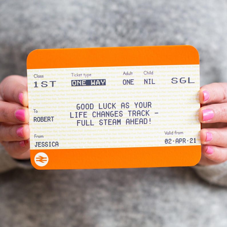 Peut inclure: Un billet de train avec un fond orange et du texte blanc. Le billet indique "Bonne chance pour le changement de voie de votre vie - plein vapeur!" et est adress&eacute; &agrave; Robert de la part de Jessica. Le billet est valable &agrave; partir du 02-APR-21.