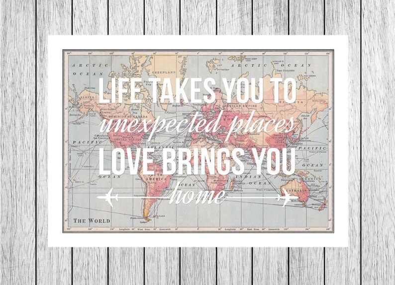 Op de afbeelding: Een vintage wereldkaart met de tekst "Life takes you to unexpected places, love brings you home" eroverheen gelegd. De kaart bevindt zich in een wit kader.