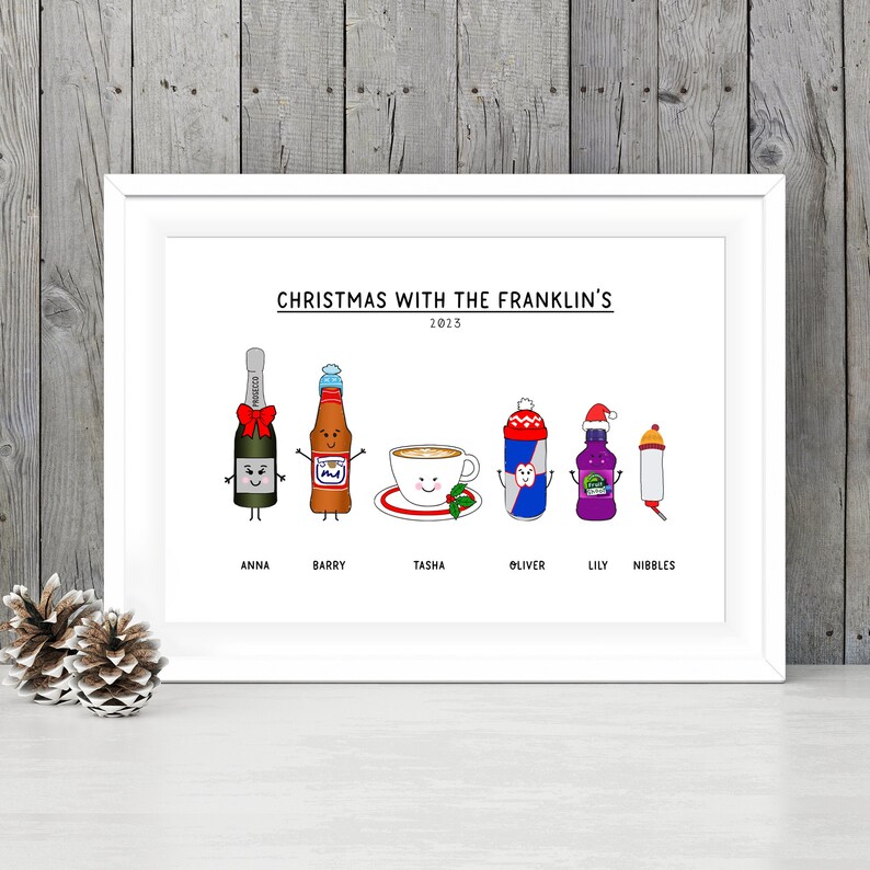 May include: A white framed print with the text "Christmas with the Franklin's 2023" at the top.  Below the text are six cartoon characters representing different beverages: a bottle of champagne, a bottle of beer, a cup of coffee, a can of energy drink, a bottle of juice, and a water bottle. Each character has a name below it: Anna, Barry, Tasha, Oliver, Lily, and Nibbles.