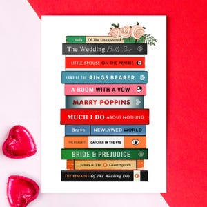 Pode incluir: Uma impress&atilde;o com uma pilha de livros coloridos com t&iacute;tulos como "The Wedding Bells Jar" e "Bride & Prejudice". H&aacute; tamb&eacute;m decora&ccedil;&otilde;es florais e dois bombons em forma de cora&ccedil;&atilde;o. O fundo &eacute; branco com uma borda vermelha.