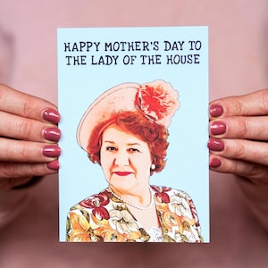Puede incluir: Tarjeta azul claro del D&iacute;a de la Madre con el texto "HAPPY MOTHER'S DAY TO THE LADY OF THE HOUSE". La tarjeta presenta un retrato de una mujer con sombrero y top con estampado floral.