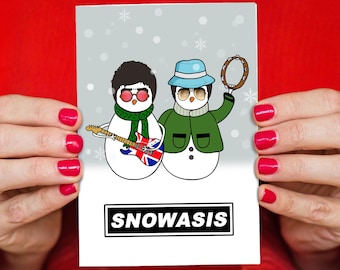 May include: A festive greeting card with two snowman illustrations. One snowman plays a guitar with a Union Jack design, the other holds a tambourine. The card reads "SNOWASIS" in a black and white box at the bottom.