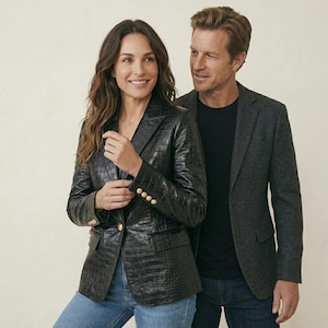 Könnte beinhalten: Ein schwarzer Blazer mit Krokodilprägung und goldfarbenen Knöpfen an den Ärmeln und der Vorderseite, kombiniert mit einer blauen Jeans. Daneben ein anthrazitfarbener Blazer über einem schwarzen T-Shirt mit dunkelblauer Jeans.