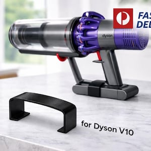 Puede incluir: Una aspiradora Dyson V10 inalámbrica con un depósito transparente y detalles morados, junto con una base de carga negra. Un accesorio negro y curvado está en primer plano. El texto "for Dyson V10" es visible.