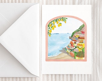 May include: A watercolor painting of a colorful Italian village on a cliffside overlooking the ocean. The scene is framed by a pink archway with a lemon tree growing over it.