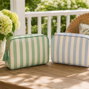 Coastal blue and sage green mahjong tile bags in gree resting on a wooden table.