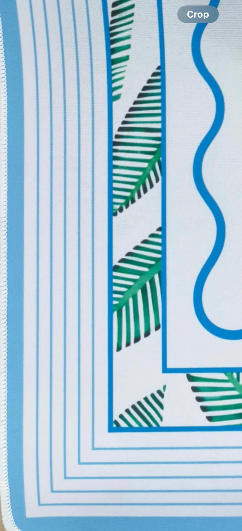 detailed view of coastal mahjong mat border. Featuring custom white stitching,  blue and white stripes, botanical leaves and a wavy line leading you to the calm center of the gameplay space