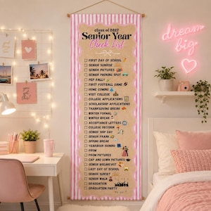 May include: A vertical wall hanging featuring a pink and white striped border surrounding a tan center with the text Senior Year Check List class of 2027. The list includes various school-related milestones with checkboxes and small icons.