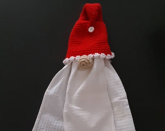 Peut inclure: Un torchon de cuisine fait à la main en forme de gnome. Le gnome a un chapeau rouge crocheté avec un bouton et une bordure blancs, un nez beige et un corps en serviette gaufrée blanche. Un article décoratif.