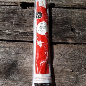 May include: A white roll of 17 inch by 5 yard fusible web, packaged in clear plastic. The packaging has red text that says "Great for", "Parfait Pour", and "Ideal Para" with a floral design. The text also says "No steam required. Machine washable."