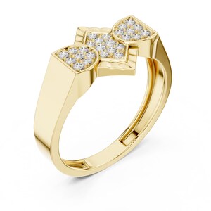 May include: A gold ring with a unique design. The ring features three sections, each adorned with small, sparkling stones. The band is a smooth, polished gold, and the overall design is modern and elegant.