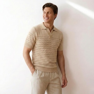 Może przedstawiać: Beżowa koszulka polo z krótkim rękawem i teksturowanym, perforowanym wzorem. Koszula ma kołnierzyk i jest połączona z beżowymi lnianymi spodniami. Strój jest w neutralnym kolorze i nadaje się do noszenia na co dzień.