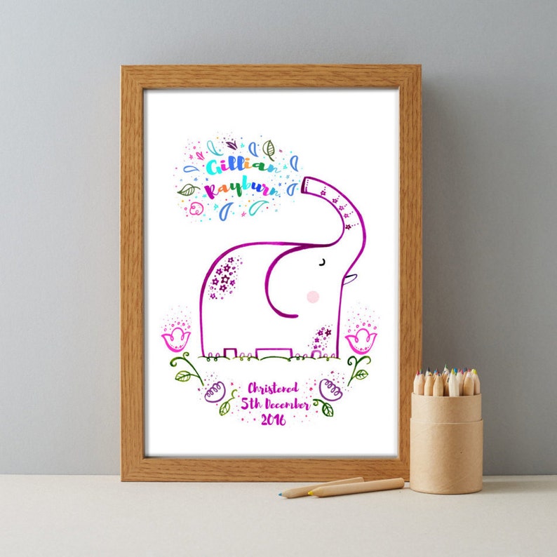 May include: A framed print with a pink elephant illustration and the text "Gillian Rayburn Christened 5th December 2016". The elephant is surrounded by colorful flowers and leaves.