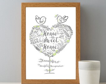 Peut inclure: Une impression encadrée avec un motif d'arbre en forme de cœur. L'arbre est rempli de petites feuilles et de fleurs. Deux oiseaux sont perchés sur des branches en haut de l'arbre. Le texte "Home Sweet Home" est écrit en cursive à l'intérieur du cœur. Les noms "Fiona & Alex" et "Woodstock Harecombs" sont écrits sous l'arbre.