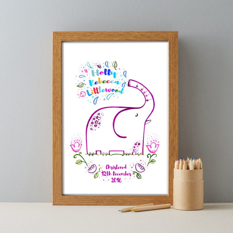 May include: A white framed print with a colorful illustration of a pink elephant with flowers. The text reads "Holly Rebecca Littlewood" and "Christened 12th December 2016".