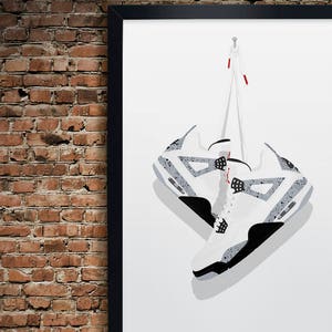 K&ouml;nnte beinhalten: Ein gerahmter Druck eines Paares wei&szlig;er und grauer Turnschuhe, die an einer Schnur h&auml;ngen. Die Turnschuhe sind ein beliebter Stil von Sportschuhen.
