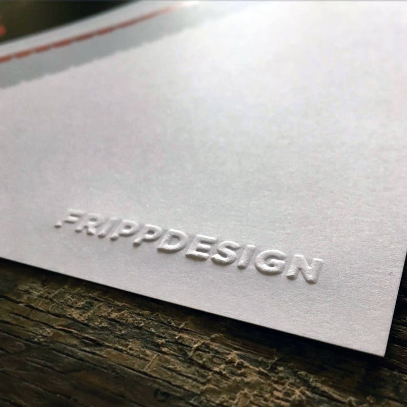 K&ouml;nnte beinhalten: Wei&szlig;e Karte mit dem gepr&auml;gten Text "FRIPP DESIGN" in einer serifenlosen Schrift.