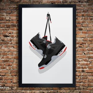 K&ouml;nnte beinhalten: Ein Paar schwarze und graue Sneaker mit roten Akzenten, die an einer Schnur h&auml;ngen. Die Sneaker h&auml;ngen vor einem wei&szlig;en Hintergrund.