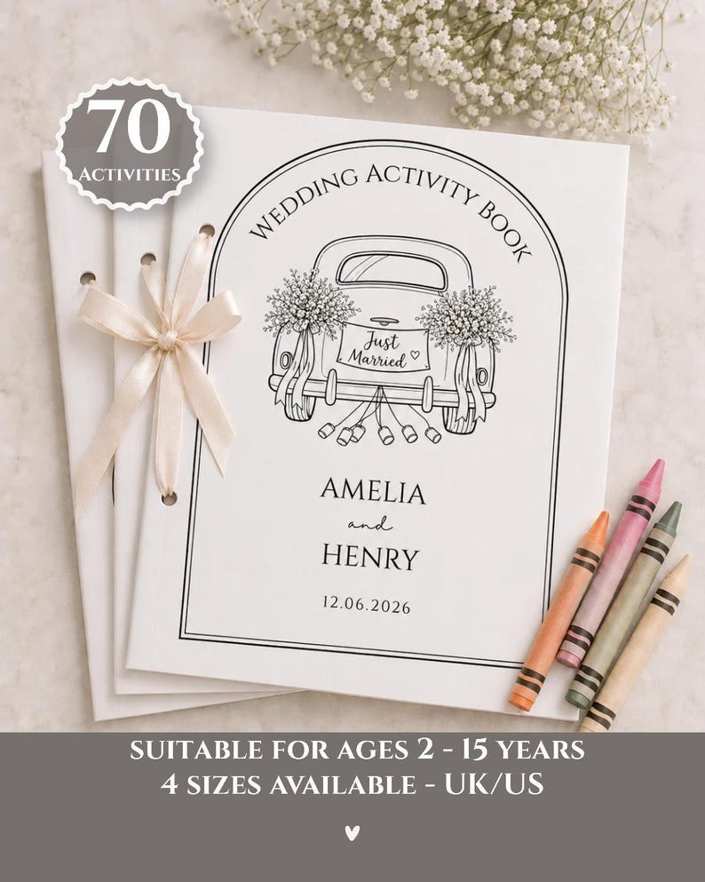 May include: A white wedding activity book with 70 activities, featuring a line drawing of a car with a Just Married sign, the names Amelia and Henry, and the date 12.06.2026. The book is bound with a cream ribbon and includes four colored crayons.