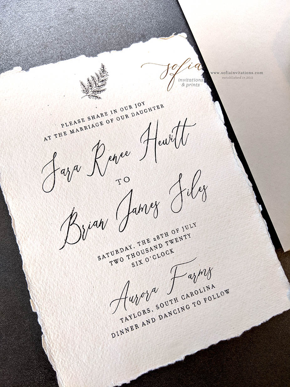 handmade paper wedding invitation with torn deckled edges and leaf